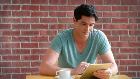 Handsome-college-student-working-on-his-digital-tablet