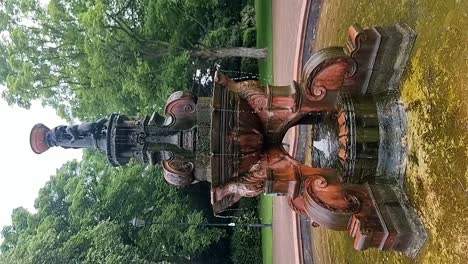 VERTICAL-Ornate-Victorian-water-fountain-slow-motion-public-park-flowing-attraction