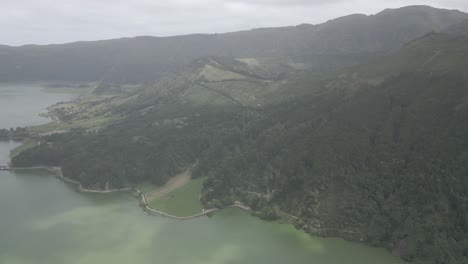 Lush-green-mountains-and-a-serene-lake-under-an-overcast-sky-in-Sete-Cidades,-Portugal