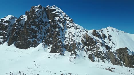 Roca-Formada-A-Lo-Largo-De-La-Cresta-De-La-Montaña,-Cobertura-De-Manto-De-Nieve-Y-Hielo,-Antena
