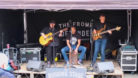 Local-musicians-in-band-playing-live-music-on-stage-at-the-popular-Frome-Farmers-Market-in-Somerset,-England