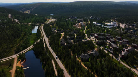 Vista-Aérea-Siguiendo-Una-Caravana-Conduciendo-Por-Saariselka,-Verano-En-Finlandia