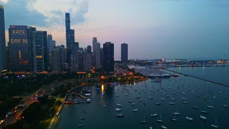 Drone-shot-of-the-beautiful-harbor-on-Lake-Michigan-and-of-Chicago's-Millennium-Park,-filmed-at-sunset