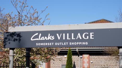 Close-up-of-entrance-sign-to-Clarks-Village-Somerset-Outlet-Shopping-retail-complex-in-the-town-of-Street,-Southwest-England