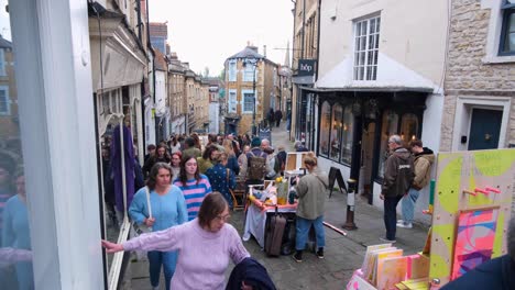 Market-stalls-on-the-streets-at-popular-Frome-Farmers-Market-with-crowds-of-visitors,-tourist-and-locals,-shopping-in-Somerset,-England