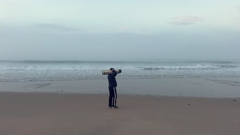 Statische-Ansicht-Eines-Mannes-In-Schwarz-Mit-Tragbarem-Klavier-Bei-Einem-Spaziergang-Am-Strand