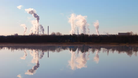 Greenhouse-gas-emissions-pollutes-atmosphere,-mirrored-reflection-in-lake