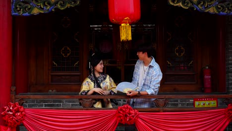 Qing-Mädchen-Und-Ihr-Freund-Lächeln-Sich-Selbstbewusst-Auf-Einem-Mit-Laternen-Geschmückten-Chinesischen-Balkon-An