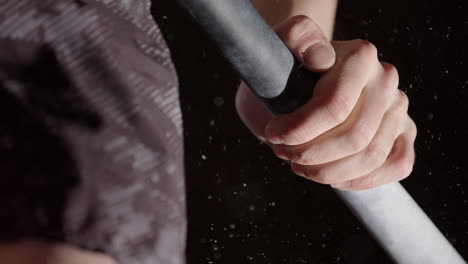 Guy-on-chin-up-bar-does-a-muscle-up-with-pronated-grip,-closeup-on-hand