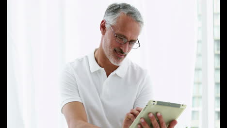 Smiling-man-using-his-tablet