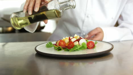 Chef-pouring-salad-dressing-over-a-salad