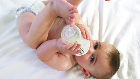 Süßes-Baby-Liegt-Und-Trinkt-Aus-Seiner-Babyflasche