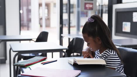 En-Un-Aula-Escolar,-Una-Joven-Afroamericana-Se-Centra-En-La-Lectura-Con-Espacio-Para-Copiar