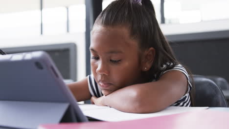 In-school-classroom,-a-young-African-American-girl-is-focused-on-her-tablet