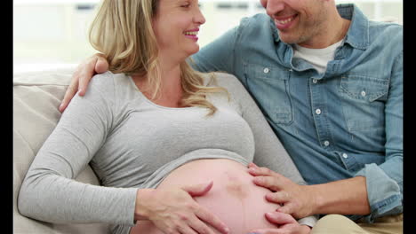 Pregnant-woman-with-her-husband-sitting-on-the-couch