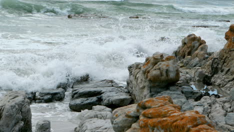 Slow-motion-of-wave-against-the-rocks-on-the-beach-4k