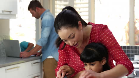 Mother-with-her-daughter-are-cooking-while-the-boys-are-repairing-the-computer