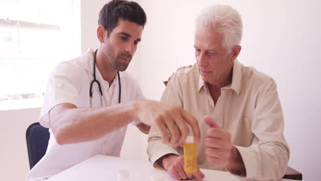 Male-doctor-giving-prescription-to-senior-man