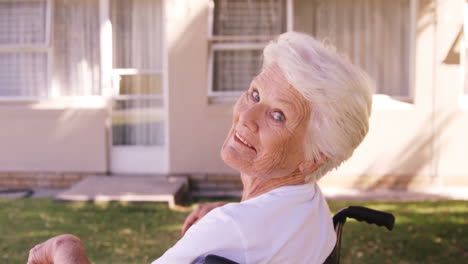 Mujer-Mayor-Sentada-En-Una-Silla-De-Ruedas-En-El-Patio-Trasero