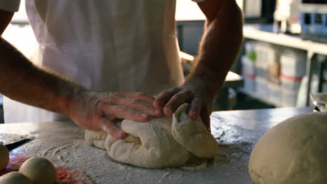 Chef-kneading-dough-on-worktop-in-kitchen-4k
