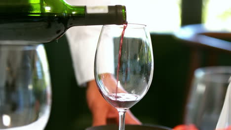 Waiter-pouring-a-bottle-of-red-wine