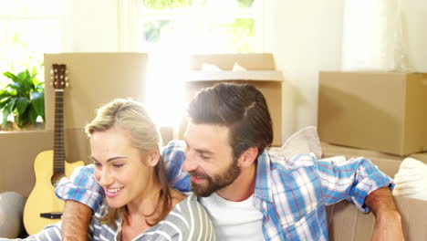 Cute-couple-sitting-against-a-cardboard-using-a-tablet