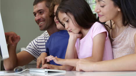 Happy-family-smiling-and-using-a-computer-together