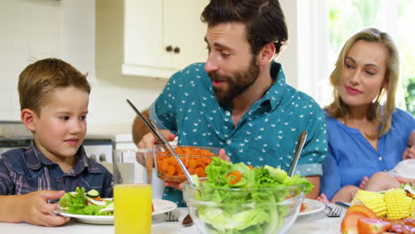 Dad-serving-carrot-to-his-son-