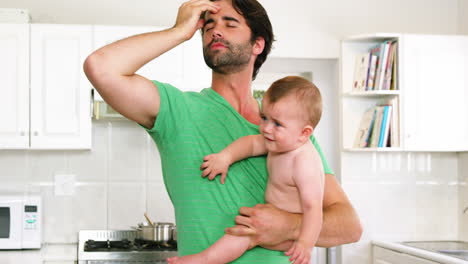 Father-holding-his-baby-and-have-a-headache-