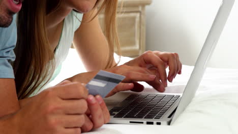 Close-up-happy-couple-going-shopping-by-internet