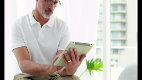 Smiling-man-using-his-tablet