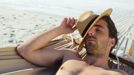 Man-wearing-hat-lying-in-hammock