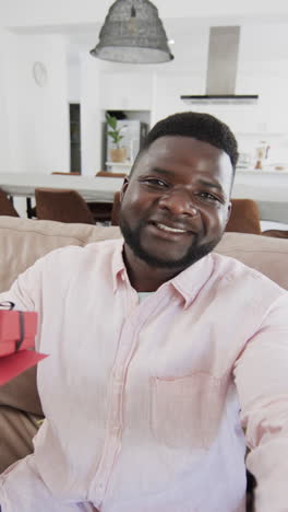 Vertical-video:-Middle-aged-African-American-man-sitting,-wearing-pink-shirt