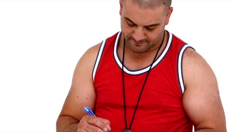 Personal-trainer-writing-on-clipboard-and-showing-thumb-up