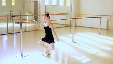 Side-view-of-ballerina-is-doing-exercises-with-a-bar