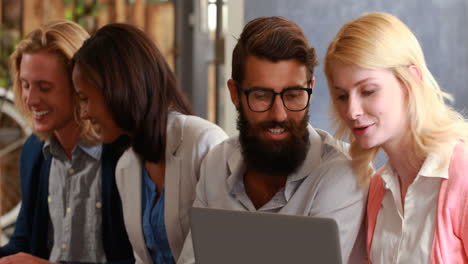 Hipster-friends-talking-and-using-laptop