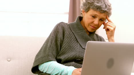 Woman-using-laptop-while-sitting