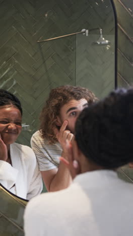 Vertical-video:-Diverse-couple-sharing-playful-moment-in-bathroom-at-home