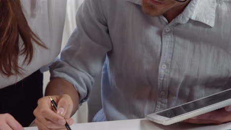 Businessman-and-woman-working-on-tablet