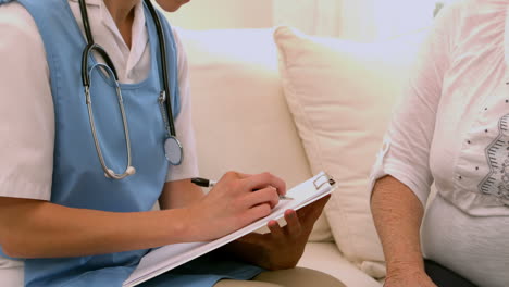 Nurse-taking-note-on-clipboard