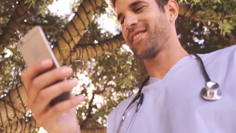 Male-doctor-using-mobile-phone-in-the-backyard-