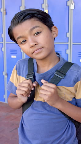 Vertikales-Video:-Ein-Kleiner-Junge-Mit-Rucksack-Steht-In-Der-Schule