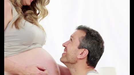Hombre-Escuchando-El-Vientre-De-Su-Esposa-Embarazada