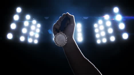 Close-up-of-sportsman-hand-holding-a-medal