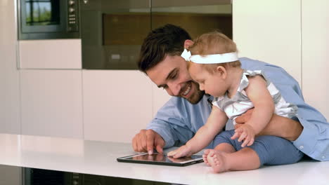 Businessman-holding-baby-using-tablet-computer