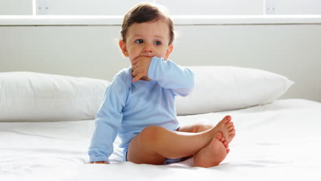 Cute-baby-with-nightwear-sitting-on-a-bed