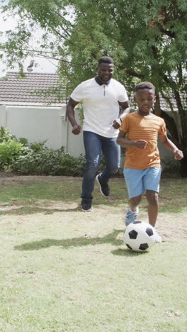 Vertical-video:-African-American-father-and-son-are-playing-soccer