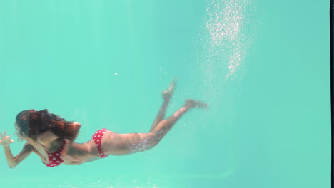 Smiling-woman-swimming-underwater