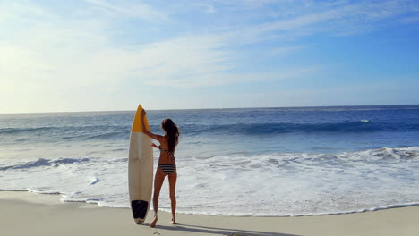 Happy-brunette-walking-with-surfboard