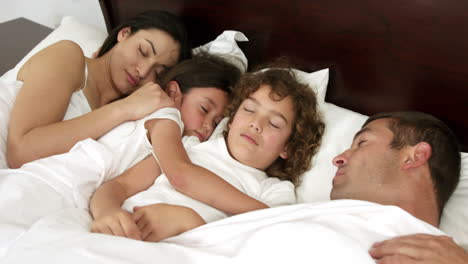 -Family-sleeping-together-on-bed